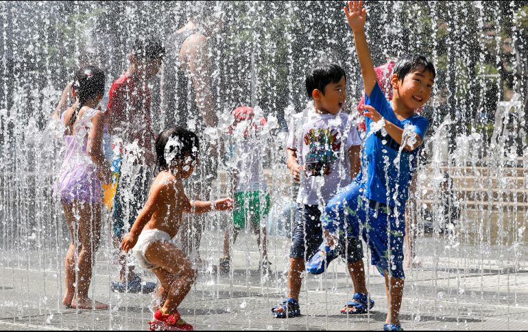 Varios niños juegan en los chorros de agua de una fuente en un parque cerca de Nerima, en Tokio. EFE/K. Mayama