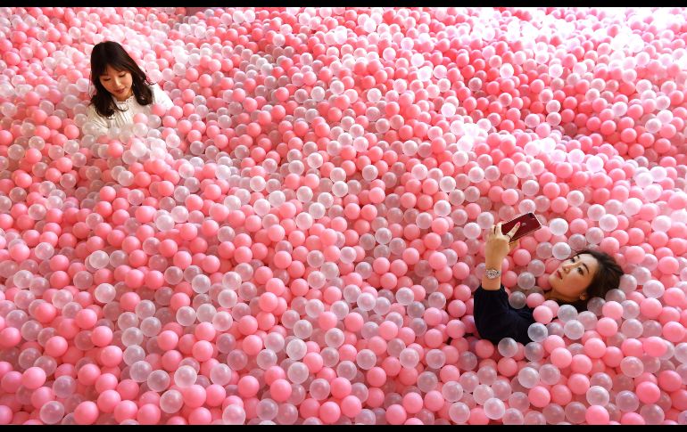 Visitantes se sumergen entre pelotas que asemejan dulces en Sugar Republic, un museo interactivo dedicado a los dulces y postres en Melbourne, Australia. AFP/W. West