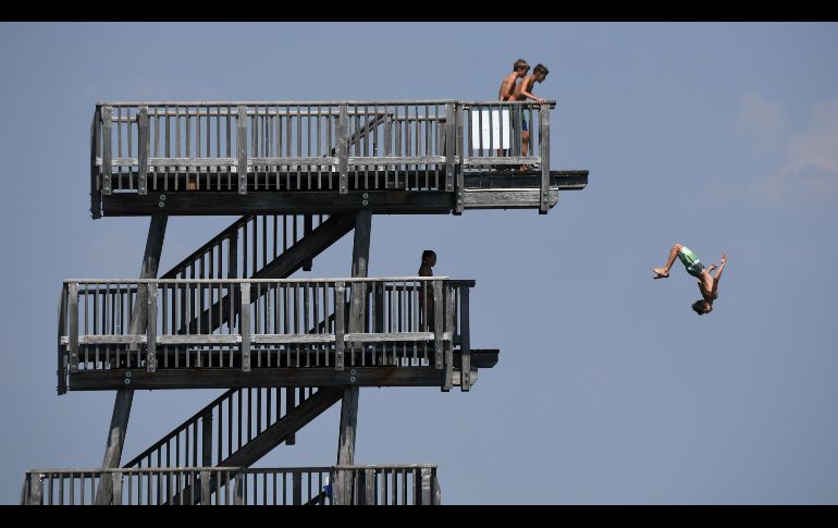 Un joven salta de una plataforma en el lago Ammersee, cerca de la población alemana de Utting. AFP/C. Stache