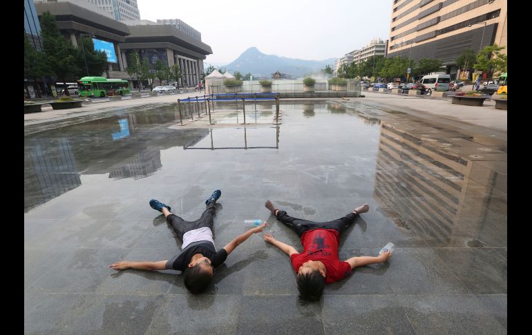 Niños esperan que una fuente comience a arrojar agua en Seúl, Corea del Sur. La ciudad emitió una alerta por una ola de calor que ha provocado temperaturas de más de 37 grados centígrados. AP/Y. Ahn