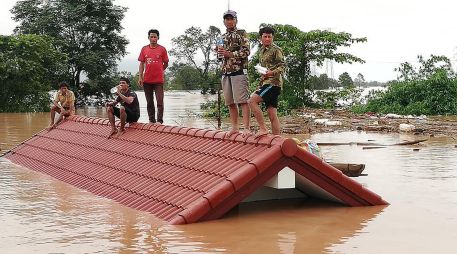 Varios afectados siguen atrapados en los tejados y azoteas de sus casas, en espera de ayuda. AFP