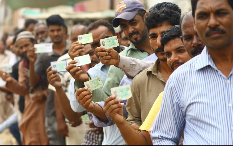 Varios votantes muestran sus documentos de identidad mientras hacen cola en un colegio electoral durante la celebración de las elecciones generales en Karachi. EFE/S. Akber