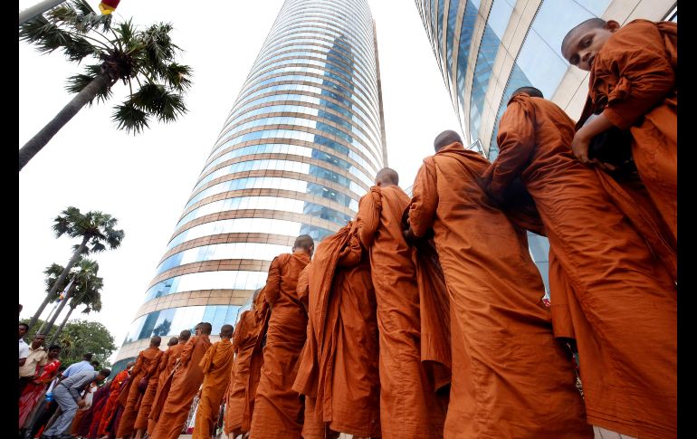 Monjes budistas del templo Sri Sambodhi caminan en procesión durante la ceremonia de entrega de limosnas en Colombo, Sri Lanka. Los monjes reciben ofrendas ya que no se les permite tener posesiones. EFE/ M. A. Pushpa