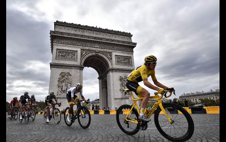El pelotón pasa por el Arco del Triunfo en París, en la vigésima primera y última etapa del Tour de Francia. El británico Geraint Thomas (d) conquistó por primera vez en su carrera el Tour. AFP/M. Bertorello
