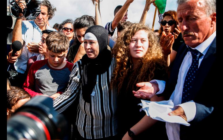 La palestina Ahed Tamimi (2 d) se ve junto a sus padres tras ser liberada de una prisión militar israelí en la ciudad cisjordana de Ramala. Tamimi, de 17 años, se ha vuelto un símbolo de la resistencia palestina, tras ser sentenciada a ocho meses de prisión por aparecer en un video enfrentándose a soldados israelíes. AFP/A. Momani