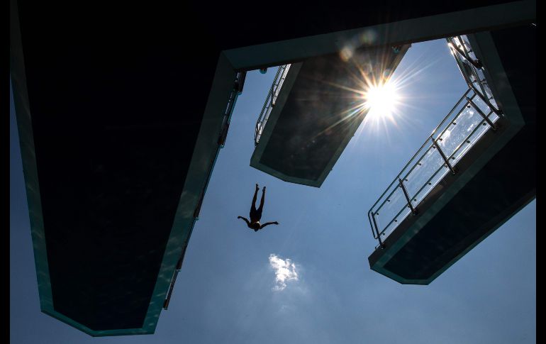 Un hombre salta a una alberca pública en Stuttgart, Alemania, donde se registran temperaturas de 34 grados centígrados. AFP/DPA/S. Gollnow