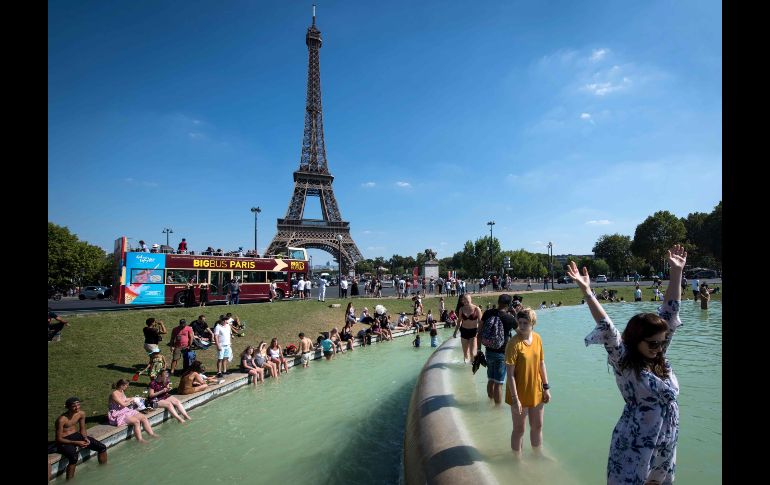 La fuente del Trocadero, frente a la torre Eiffel, atrae a personas que buscan refrescarse. AFP/G. Julien