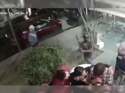 Mientras uno amaga con accionar su arma de fuego, otro comienza a golpear a un hombre con playera amarilla. TWITTER / SUN Oaxaca