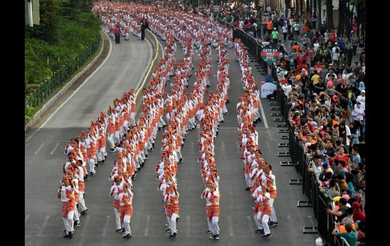 Una presentación del tradicional baile Poco-poco recorre las calles de Yakarta, Indonesia, durante un intento de batir un récord mundial con 65 mil bailarines para promover los Juegos Asiáticos. AFP/G. Chai Hin