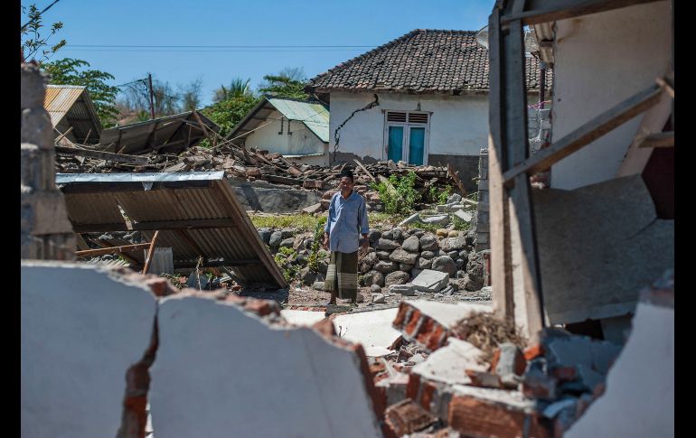 Un hombre inspecciona los daños en Kayangan, en la isla indonesia de Lombok, tras el sismo de ayer que ha provocado al menos 98 muertes. AP/F. Chaniago
