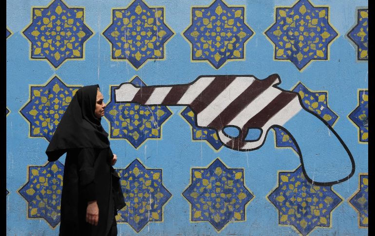 Una mujer pasa por un mural en la pared de la ex embajada de Estados Unidos en Teherán, Irán. AFP/A. Kenare