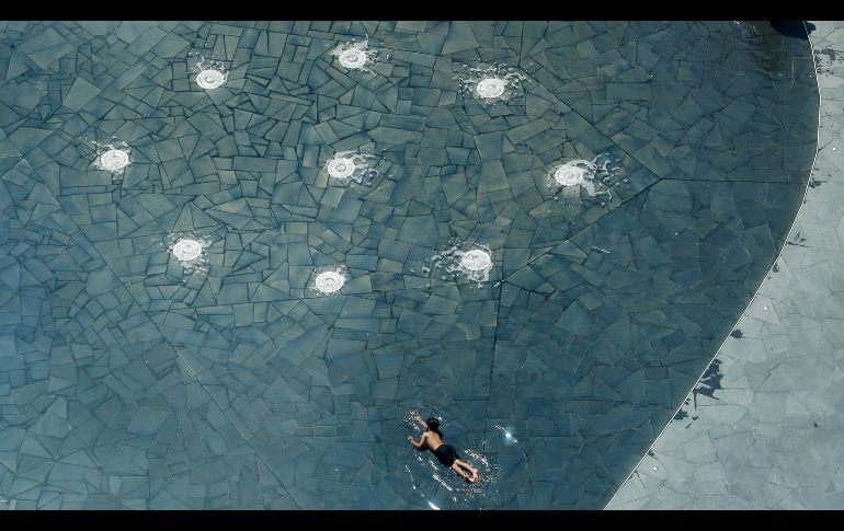 Un niño pretende nadar en una fuente en Milán, Italia. AP/A. Calanni