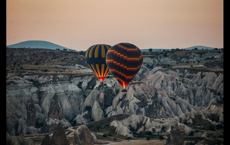 Globos aerostáticos con turistas se elevan durante el amanecer en Capadocia, Turquía. Las 