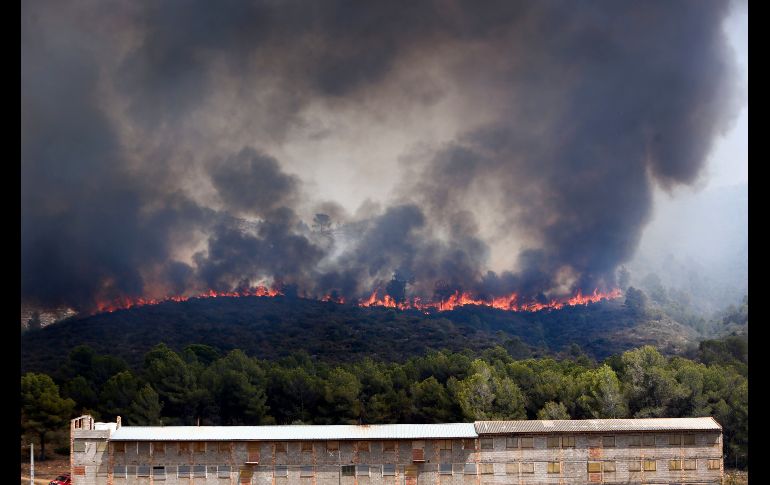 Bomberos combaten un incendio forestal en Pinet, España. AP/A. Saiz