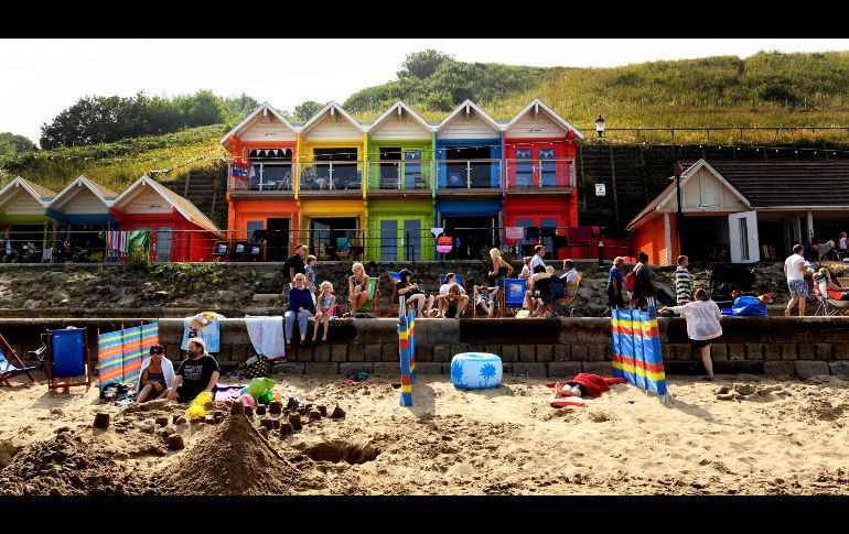 Personas disfrutan el Sol en una playa de Scarborough, Inglaterra. AFP/P. Ellis