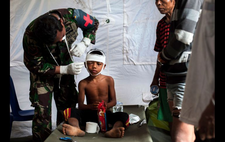Un paramédico militar auxilia a un niño lesionado por el sismo del domingo en Kayangan, en la isla indonesia de Lombok. AP/F. Chaniago