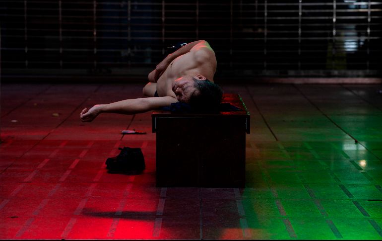 Un hombre duerme frente a un centro comercial para huir del calor en las zonas residenciales de Shanghái, China. Muchas viviendas de la ciudad carecen de aire acondicionado. AFP/J. Eisele