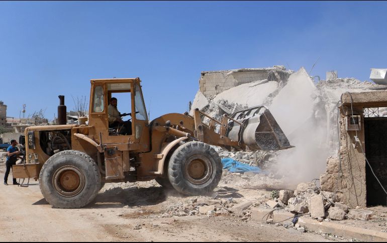 Equipos de rescate intentan retirar escombros del edificio destruido usando una grúa y una excavadora. AFP/A. Watad