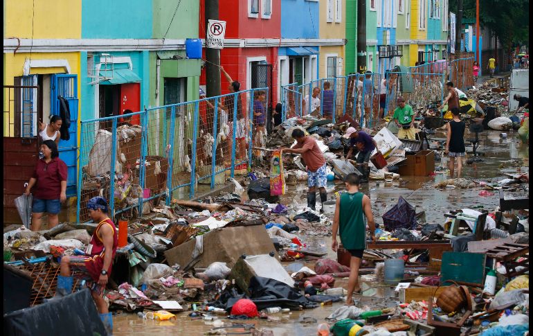 Habitantes limpian sus casas tras los daños causados por lluvias y fuertes vientos de una tormenta tropical en Marikina, Filipinas. AP/B. Marquez