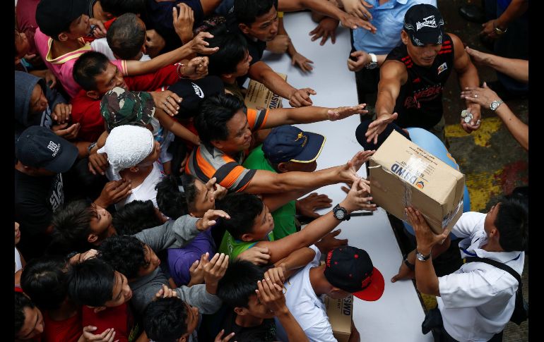 Residentes se agolpan para recibir ayuda humanitaria en un centro de evacuación en Manila, Filipinas. Al menos dos personas han muerto en Filipinas por las inundaciones que afectan a más de un millón de personas a raíz del paso de la tormenta tropical 