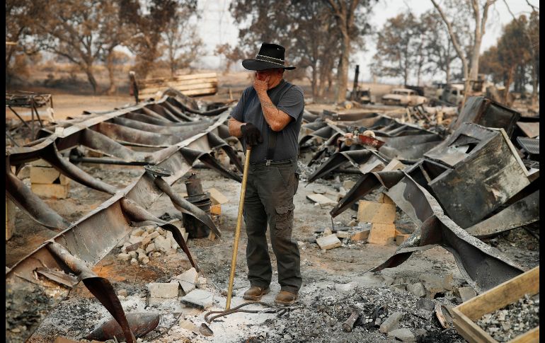 Ed Bledsoe reacciona mientras busca entre los escombros de su casa en Redding, California. Su esposa y dos bisnietos murieron en la casa debido al incendio Carr en la entidad.