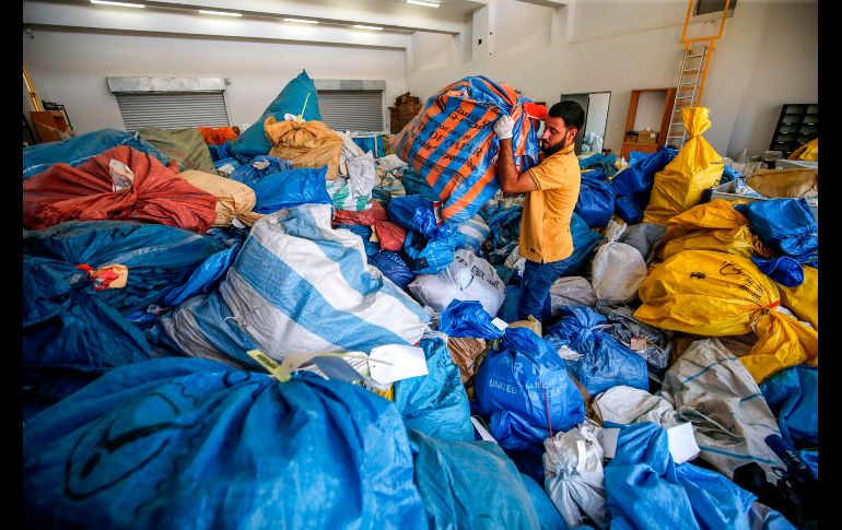 Un trabajador postal se ve entre sacos de correo no entregado que data hasta de 2010 en Jericó, Cisjordania. Israel había retenido correo por años y finalmente lo entregó a autoridades palestinas tras un acuerdo. AFP/A. Momani