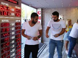 Varias personas acuden a una oficina de cambio de divisas en Estambul. EFE/E. Sahin