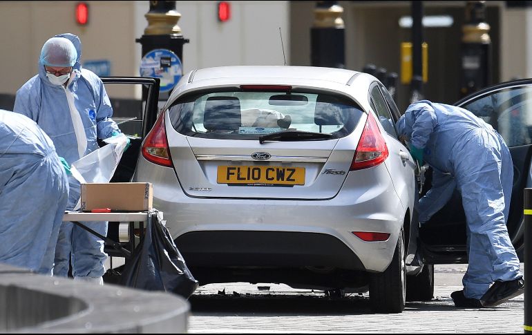 Oficiales forenses examinan el coche que chocó contra las barreras del Parlamento británico en Londres. EFE/A. Rain
