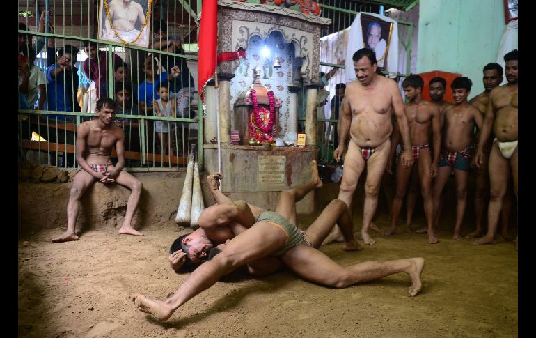 Hombres participan en una lucha tradicional en Allahabad, India, durante el festival hindú 