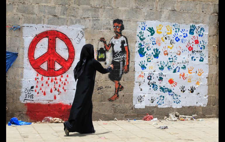 Una artista pinta un grafiti por la paz en un muro de Saná, Yemen. Varios artistas urbanos han pintado varios murales en las calles de la ciudad para pedir paz y tolerancia y para mostrar su rechazo al conflicto en el que está sumido el país árabe. EFE/ Y.  Arhab