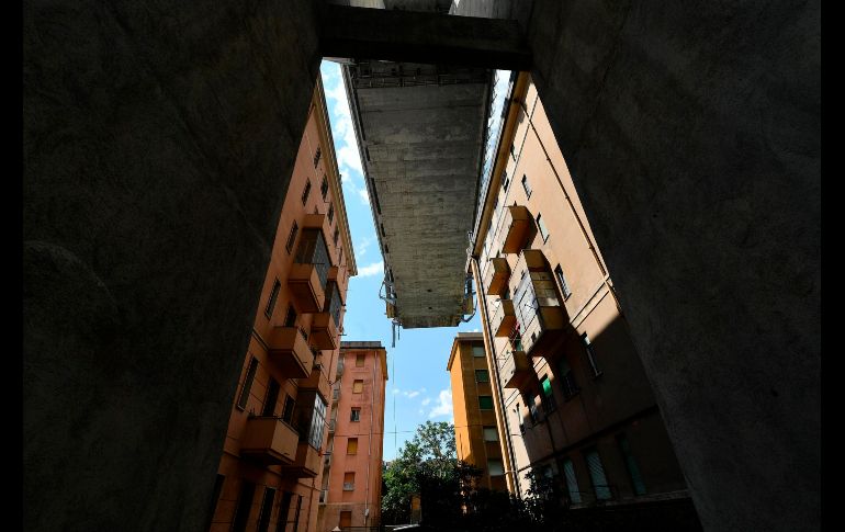 Un tramo del puente Morandi en Génova, Italia, se ve sobre viviendas. Autoridades anunciaron que los edificios bajo el viaducto no volverán a ser habitables.