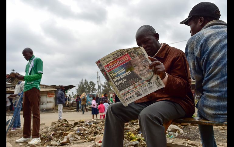 Hombres leen en Nairobi, Kenia, un periódico local que dedica su portada al legado de Kofi Annan, el ex director general de Naciones Unidas que falleció el sábado a los 80 años. AFP/T. Karumba