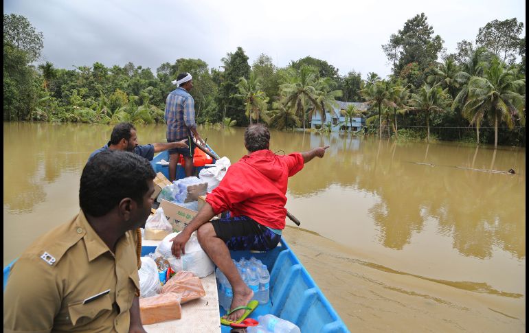 Voluntarios llevan artículos esenciales a personas varadas en un área inundada en Chengannur, Kerala. AP/A. Rahi