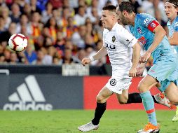 El delantero francés del Valencia CF Kevin Gameiro (i) persigue el balón junto al uruguayo Diego Godín (c) y el brasileño Filipe Luis (d), ambos del Atlético de Madrid, durante el juego. EFE/M. Bruque
