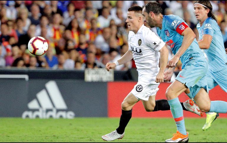 El delantero francés del Valencia CF Kevin Gameiro (i) persigue el balón junto al uruguayo Diego Godín (c) y el brasileño Filipe Luis (d), ambos del Atlético de Madrid, durante el juego. EFE/M. Bruque