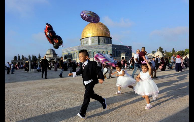 Palestinos juegan con globos cerca de la mezquita del Domo de la Roca en Jerusalén. Musulmanes de todo el mundo han comenzado hoy el Eid al-Adha, o la Fiesta del Sacrificio, que se prolongará los próximos tres días. AP/M. Illean