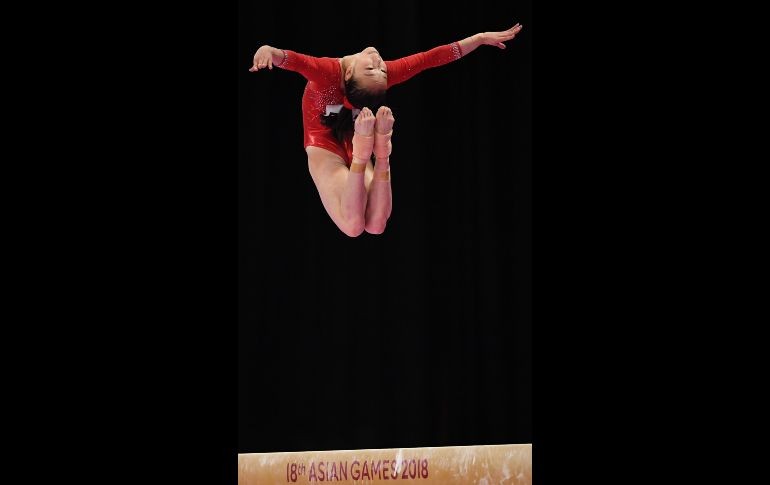 La gimnasta china Jin Zhang ejecuta su ejercicio sobre la barra de equilibrio durante la ronda clasificatoria femenina de gimnasia artística de los Juegos Asiáticos en Yakarta, Indonesia. AFP/P. Parks