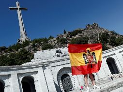 Un hombre en el Valle de los Caídos despliega la bandera la España franquista. EFE/Mariscal
