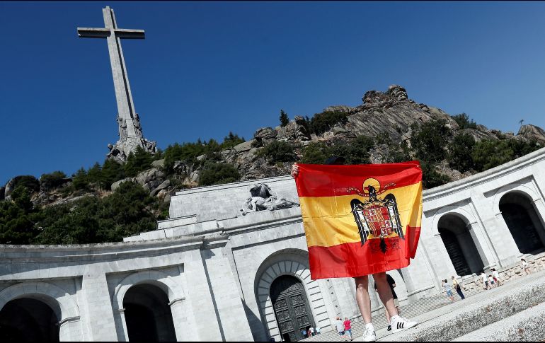 Un hombre en el Valle de los Caídos despliega la bandera la España franquista. EFE/Mariscal