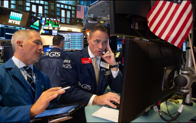 Operadores trabajan en el piso en la campaña de apertura del Dow Industrial Average, en la Bolsa de Nueva York. AFP/R. Smith