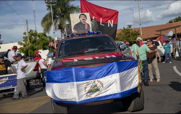 Simpatizantes exhiben una fotografía del presidente nicaragüense, Daniel Ortega, durante una marcha del oficialista Frente Sandinista de Liberación Nacional. EFE/J. Torres
