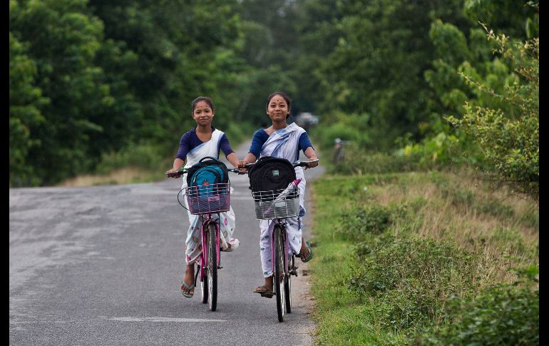 Niñas se dirigen a sus casas tras salir de la escuela en Gauhati, India. La bicicleta es un medio común de transporte para estudiantes en las áreas rurales. AP/A. Nath
