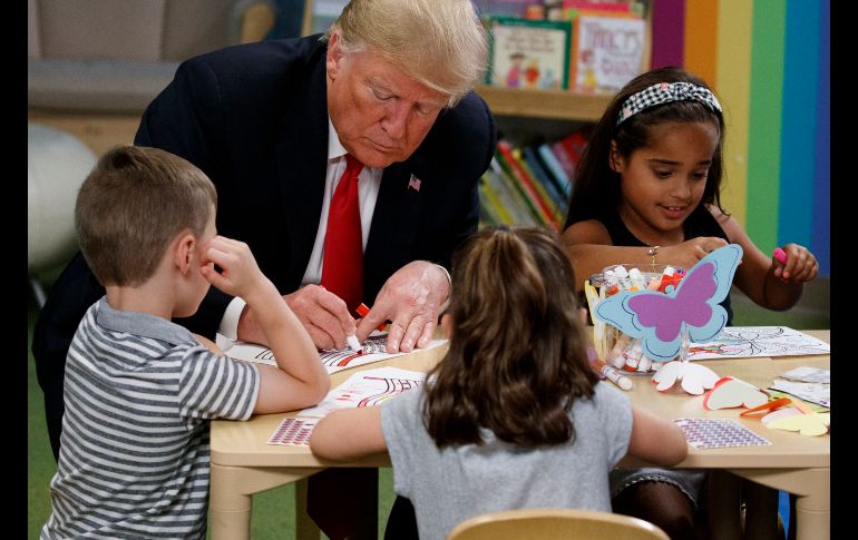 El presidente estadounidense Donald Trump colorea durante una visita a niños en el hospital Nationwide Children en Columbus, en el estado de Ohio. AP/E. Vucci