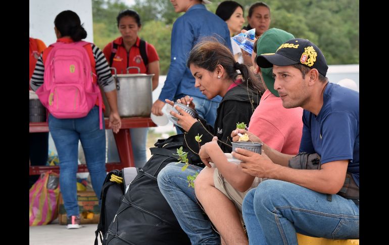 Migrantes toman alimentos en un centro en Huaquillas, Ecuador, en la frontera con Perú.