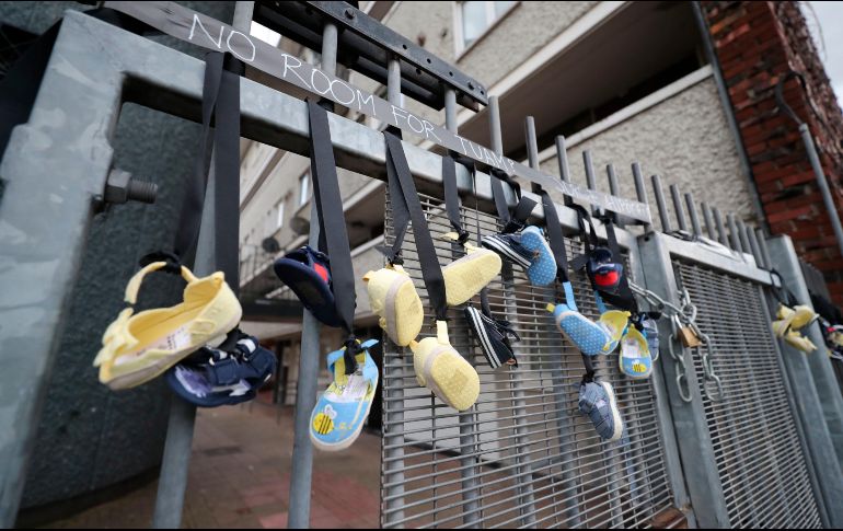 Varios zapatos de bebé cuelgan de la barandilla de la calle Sean McDermott, en Dublín, en recuerdo de los niños que murieron en la casa para huéranos de Bon Secours. AP/B. Lewess