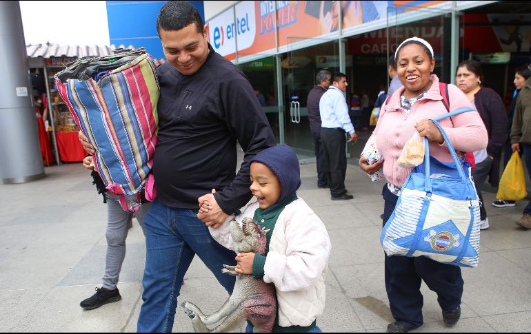 Una familia venezolana sale de la terminal de autobuses en el norte de Lima. AFP/T. Bizca