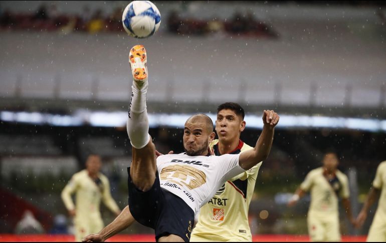 El jugador Edson Álvarez (atrás) de América disputa el balón con Carlos González (frente) de Pumas. EFE/J. Méndez