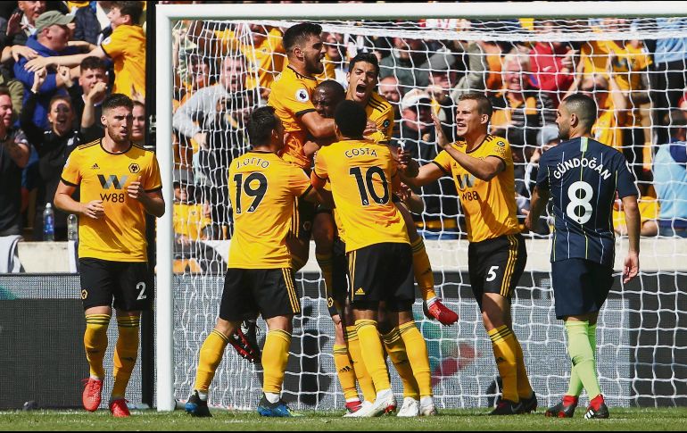 Raúl Jiménez y sus compañeros del Wolverhampton abrazan a Willy Boly tras su anotación contra el Manchester City. AFP
