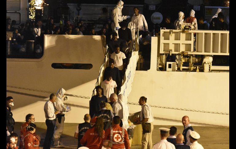 Inmigrantes desembarcan del buque de los guardacostas Diciotti en el puerto de Catania,  Italia, en la madrugada. EFE/O. Scardino