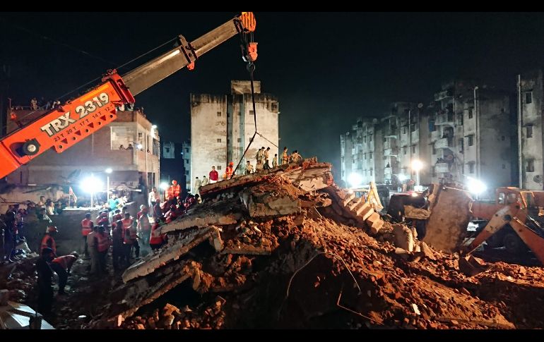 Personal de emergencias y voluntarios trabajan para hallar a personas atrapadas en los escombros de un edificio residencial que colapsó en Ahmedabad, India. AFP/S. Panthaky